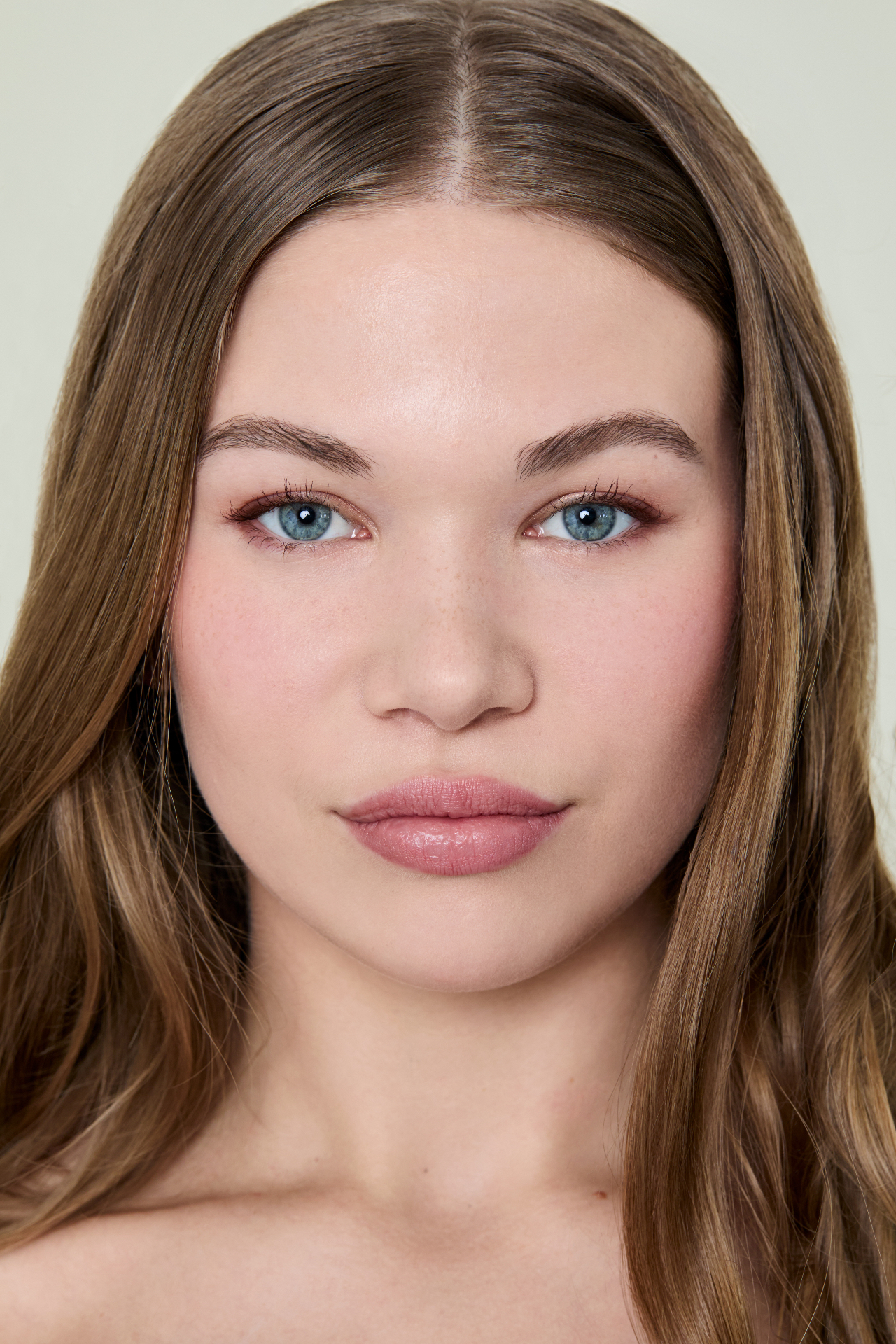 Soft glam beauty portrait with glowing skin and peachy tones