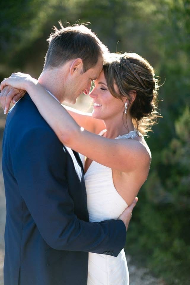 Bride and groom embracing in golden sunlight on their wedding day